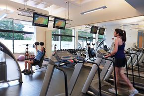 Boston apartment for rent - A woman is running on a treadmill in a gym with a man on a rowing machine in the background.