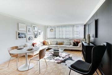 Boston apartment for rent - A modern living room with a white dining table and a white sofa.