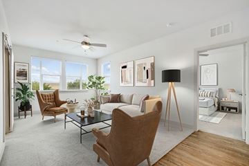 Kissimmee apartment for rent - A living room with a brown chair in the foreground and a white couch in the background.