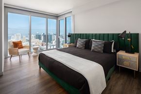 San Diego apartment for rent - A bedroom with a large bed and a view of the city.