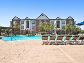 Pearland apartment for rent - A large building with a pool in front of it.