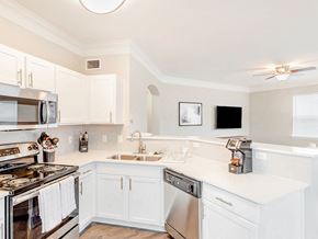 Pearland apartment for rent - A kitchen with white cabinets and a stove top oven.