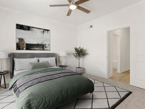 Pearland apartment for rent - A bedroom with a large bed and a ceiling fan.
