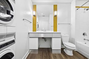Dallas apartment for rent - A modern bathroom with a washing machine built into the wall.