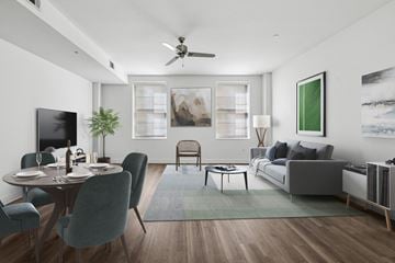 Dallas apartment for rent - A modern living room with a dining table set for two and a grey couch.