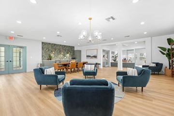 Tampa apartment for rent - A living room with blue chairs and a wooden table.