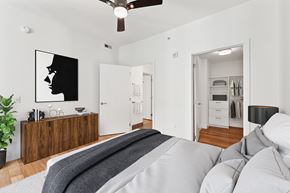 Washington apartment for rent - A bedroom with a bed in the foreground and a painting of a woman's profile on the wall.