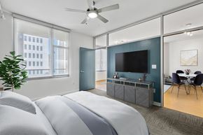 Dallas apartment for rent - A bedroom with a large bed and a television in the corner.