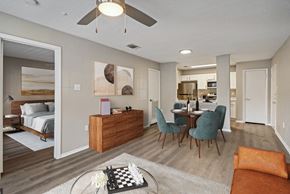 Irving apartment for rent - an open living room and dining room with a bed in the background and a dining