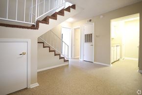 Baton Rouge apartment for rent - A white door is on the left of a hallway with a staircase.