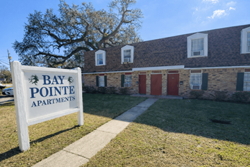 Mobile apartment for rent - A sign for Bay Pointe Apartments stands in front of a brick building.