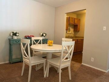 Mobile apartment for rent - A dining room with a white table and chairs.