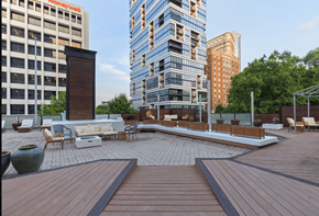Atlanta apartment for rent - A wooden deck with chairs and a table in the middle of a courtyard surrounded by buildings.
