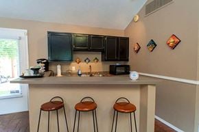 Little Rock apartment for rent - a kitchen with a bar and three stools in front of a counter top