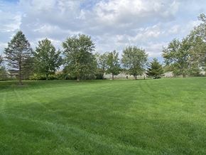 Bloomington apartment for rent - a large grass field with trees in the background