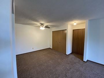 Bloomington apartment for rent - a living room with carpet and a ceiling fan