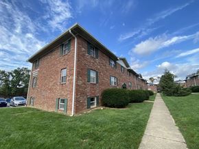 Bloomington apartment for rent - a brick apartment building with green grass and a sidewalk
