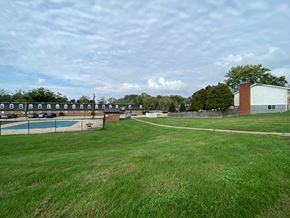 Bloomington apartment for rent - a view of a park with a tennis court and a pool