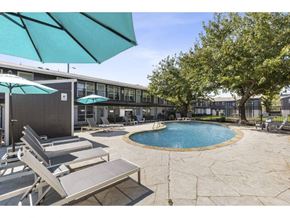 Denton apartment for rent - a pool with chairs and umbrellas next to a building