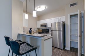 Houston apartment for rent - A kitchen with a refrigerator, microwave, oven, and sink.