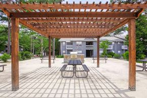 Rossville apartment for rent - a picnic area with a table and benches under a wooden pergola
