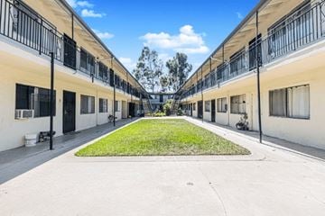 Lynwood apartment for rent - A long row of identical houses with balconies and green lawns.