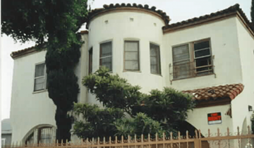 Los Angeles apartment for rent - A white house with a red roof and a fence in front.