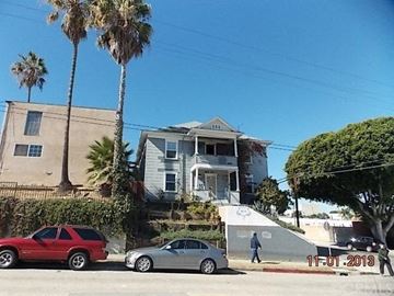 San Pedro apartment for rent - A red car is parked on the left side of a street, and a silver car is parked on the right side.