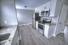 Tonawanda apartment for rent - an empty kitchen with white cabinets and stainless steel appliances
