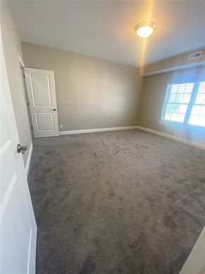Getzville apartment for rent - an empty living room with a carpeted floor and a window