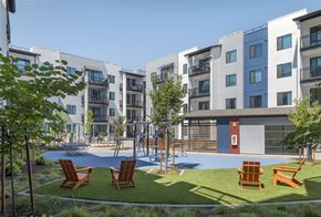 Fairfield apartment for rent - A modern apartment complex with a playground and seating area.