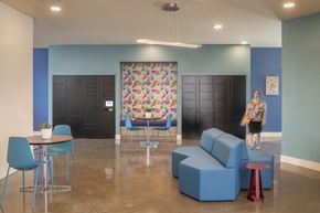 Hayward apartment for rent - A woman walks through a blue and white room with a table and chairs.