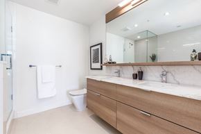 Calgary apartment for rent - A bathroom with a toilet, sink, and mirror.
