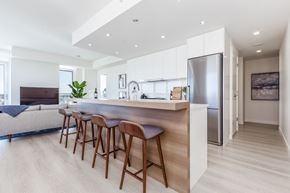 Calgary apartment for rent - A modern kitchen with a bar area and wooden flooring.