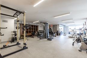 Calgary apartment for rent - A gym with a variety of equipment including weights and machines.
