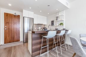 Calgary apartment for rent - A modern kitchen with white cabinets and a wooden door.