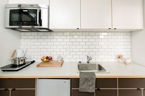 Victoria apartment for rent - A modern kitchen with a microwave, sink, and refrigerator.