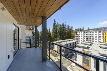 North Vancouver apartment for rent - A balcony with a wooden ceiling overlooks a courtyard and buildings.
