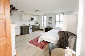 Victoria apartment for rent - A bedroom with a bed, chair, and a rug.