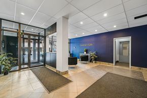 Calgary apartment for rent - A hallway with a blue wall and a sign that says "Central at 12th".
