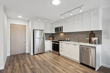 Maple Ridge apartment for rent - A kitchen with white cabinets and a wooden floor.