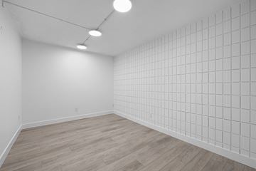 Calgary apartment for rent - A room with a white tile wall and wooden flooring.