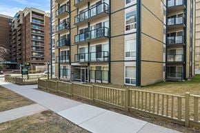 Calgary apartment for rent - A view of apartment buildings with balconies and a sidewalk.