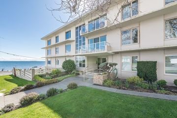 Nanaimo apartment for rent - A white building with a balcony overlooking the ocean.