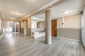Nanaimo apartment for rent - A long hallway with a white ceiling and grey flooring.