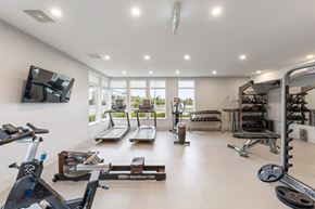 Surrey townhouse for rent - A well-lit home gym with a variety of exercise equipment.