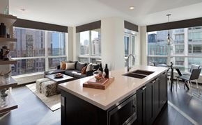 Calgary apartment for rent - A modern kitchen with a large island and a view of the city.