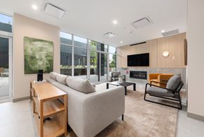 Coquitlam apartment for rent - A modern living room with a grey sofa, a wooden table, and a television.