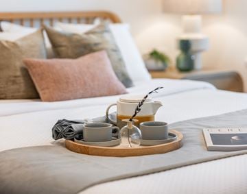 Surrey townhouse for rent - A tray with tea set and a book titled "GIRL" is on a bed.
