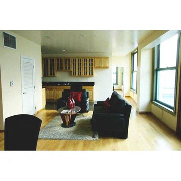 Los Angeles apartment for rent - A living room with a black couch and a red vase on a coffee table.
